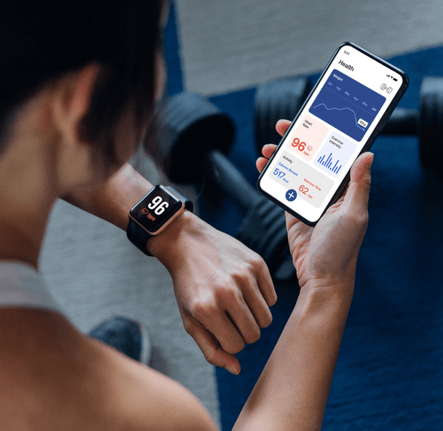 Person checking health stats on phone and smartwatch